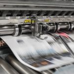 close-up of a printing press with vibrant paper being processed