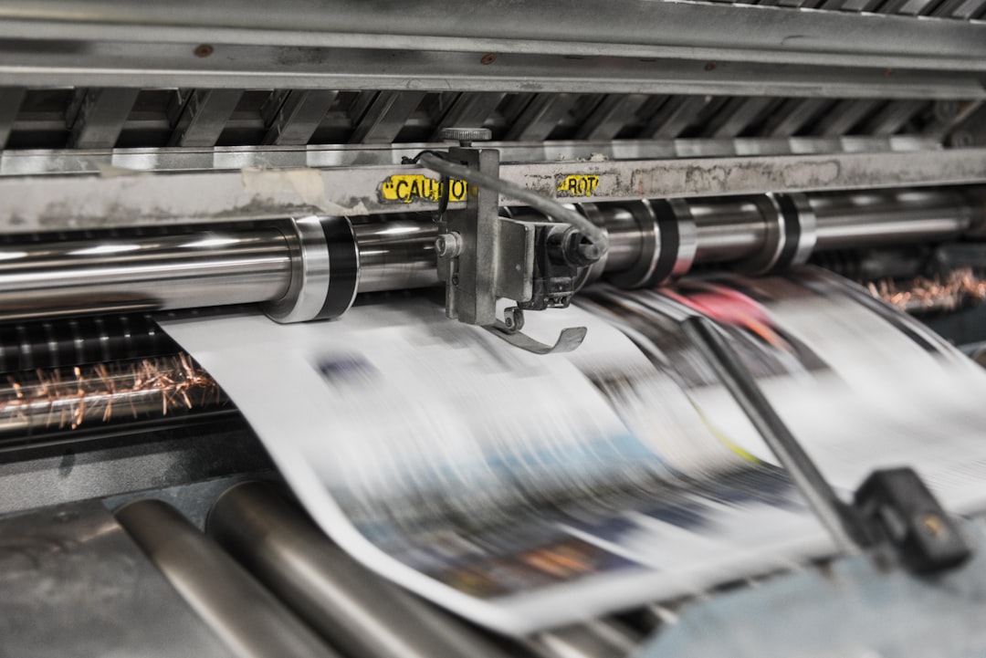 close-up of a printing press with vibrant paper being processed